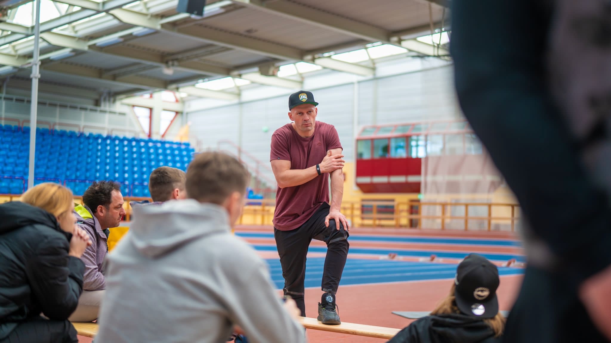 Jörg leitet ein Seminar in der Leichtathletikhalle und erklärt den Teilnehmenden einen Zusammenhang